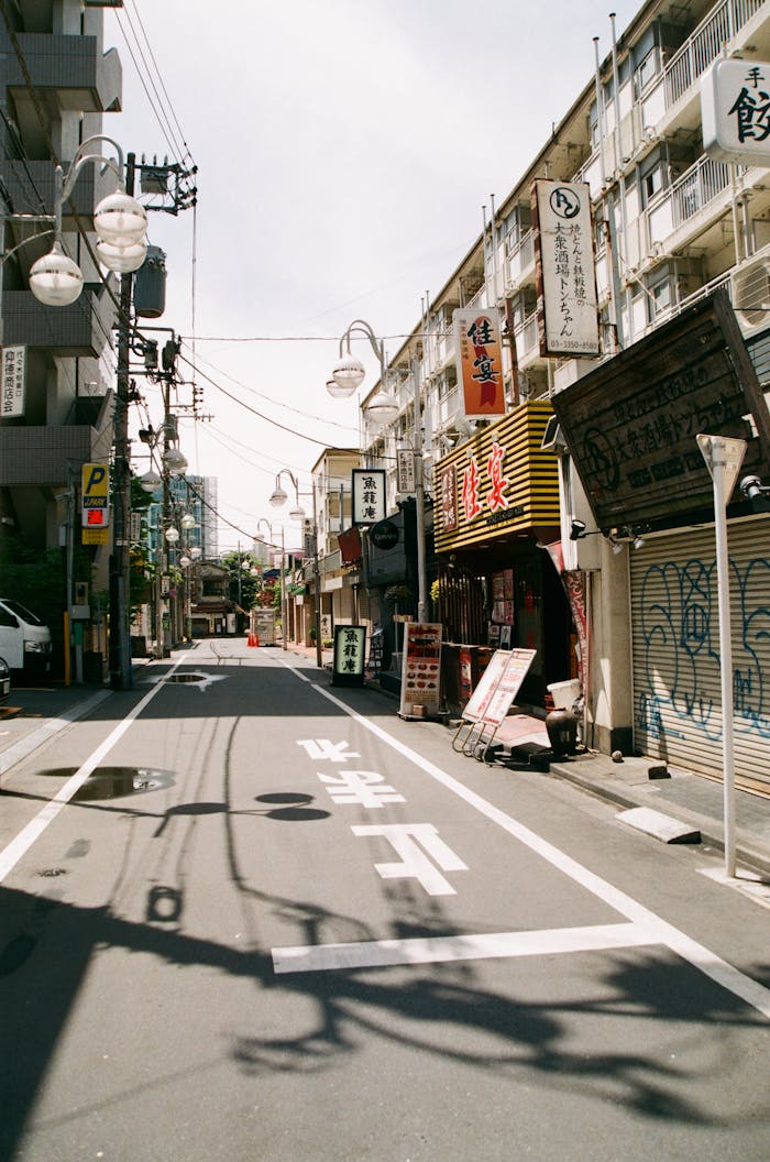 about-01 Empty street scene in Tokyo, Japan showcasing traditional Japanese shopfronts and urban architecture.